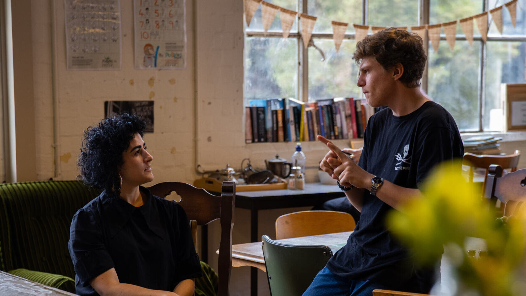 Person signing in Auslan to a colleague in a workplace setting